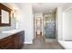 Stylish bathroom featuring a walk-in shower with glass door and dark wood cabinets at 2451 S Fenton Dr, Lakewood, CO 80227