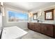 Bright bathroom boasts a double sink vanity, a large window, and a soaking tub at 2451 S Fenton Dr, Lakewood, CO 80227