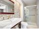 Bathroom featuring tiled accent wall, modern sink, glass shower, and contemporary fixtures at 2451 S Fenton Dr, Lakewood, CO 80227