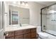 Bright bathroom featuring a single sink vanity and tub with glass doors at 2451 S Fenton Dr, Lakewood, CO 80227