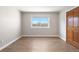 Well-lit bedroom featuring hardwood floors, a window with a backyard view, and a closet at 2451 S Fenton Dr, Lakewood, CO 80227