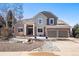 Charming two-story home featuring a brick facade, tile roof, manicured yard, and an attached two-car garage at 2451 S Fenton Dr, Lakewood, CO 80227