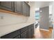 A hallway leading to a living area with hardwood floors and a built-in countertop with grey cabinetry at 2451 S Fenton Dr, Lakewood, CO 80227