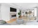 Open-concept living room with fireplace, hardwood floors, and seamless flow to the kitchen and dining area at 1284 Tennyson St # 1, Denver, CO 80204