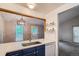 Modern kitchen featuring blue cabinets, stainless steel sink, dishwasher and an open design to dining area at 10441 Routt Ln, Broomfield, CO 80021