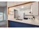 Bright kitchen featuring white cabinets, blue lower cabinets and a breakfast bar with open access to the living room at 10441 Routt Ln, Broomfield, CO 80021