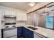 Updated kitchen with white appliances, blue and white cabinetry, and subway tile backsplash at 10441 Routt Ln, Broomfield, CO 80021