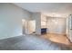 Open-concept living room featuring plush carpeting, gray walls, and an open view of the modern kitchen at 10441 Routt Ln, Broomfield, CO 80021