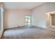 Bright and spacious living room with carpet, sliding glass door, and neutral color palette at 10441 Routt Ln, Broomfield, CO 80021