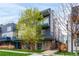 Modern townhouse featuring a blue accented exterior, complemented by fresh spring foliage and a well-manicured lawn at 1941 Hooker St, Denver, CO 80204