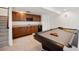 A finished basement area has a pool table, bar with cabinets, and access to the stairs at 4400 S Ensenada St, Aurora, CO 80015