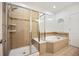 A shower and large soaking tub with tile surround highlights this bathroom at 4400 S Ensenada St, Aurora, CO 80015