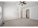 A large main bedroom boasts neutral walls and carpet plus a ceiling fan and arched entryways at 4400 S Ensenada St, Aurora, CO 80015