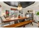 Elegant dining room featuring a large wooden table, bench seating, and a statement chandelier at 5224 Knobcone Dr, Castle Rock, CO 80108