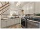 Laundry room with white cabinets, granite countertops, and modern appliances at 5224 Knobcone Dr, Castle Rock, CO 80108