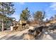 Outdoor patio with stone fireplace, seating area, and wood storage at 5224 Knobcone Dr, Castle Rock, CO 80108