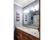 Updated bathroom featuring granite counters, wood cabinets, and elegant lighting at 6705 Youngfield Ct, Arvada, CO 80004