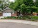 Charming brick home with a well-manicured front yard, mature trees, and a welcoming entrance at 6705 Youngfield Ct, Arvada, CO 80004