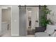 Hallway showcasing a modern barn door, a plant, and a glimpse into the closet at 2528 Concord Cir, Lafayette, CO 80026