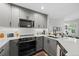 Modern kitchen with stainless steel appliances, granite countertops, subway tile backsplash, and gray cabinets at 2528 Concord Cir, Lafayette, CO 80026