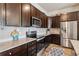 This contemporary kitchen features granite countertops, stainless steel appliances, and dark wood cabinets at 9291 Twenty Mile Rd # 106, Parker, CO 80134