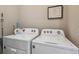 A clean, well-lit laundry area featuring white washer and dryer units with a storage shelf above at 9291 Twenty Mile Rd # 106, Parker, CO 80134