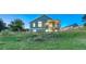 Exterior view of a home featuring a deck, yard, and natural landscaping at 1838 Mountain Daisy Ct, Highlands Ranch, CO 80129
