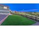 Expansive backyard with artificial turf, framed by a rustic wooden fence and a hillside backdrop at 1838 Mountain Daisy Ct, Highlands Ranch, CO 80129