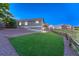 Spacious backyard featuring manicured artificial turf and a charming fence, surrounded by lush greenery at 1838 Mountain Daisy Ct, Highlands Ranch, CO 80129