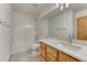 Bright bathroom with tile flooring, tub with tile surround, modern vanity, and large mirror at 1838 Mountain Daisy Ct, Highlands Ranch, CO 80129