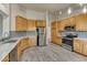 Open-concept kitchen with stainless steel appliances and wood-style tile flooring at 1838 Mountain Daisy Ct, Highlands Ranch, CO 80129