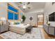 A spacious main bedroom featuring stylish décor, a ceiling fan, and ensuite bathroom access at 1838 Mountain Daisy Ct, Highlands Ranch, CO 80129