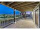 Covered outdoor patio with wood railing and a staircase leading to the backyard at 1838 Mountain Daisy Ct, Highlands Ranch, CO 80129