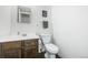 Cozy bathroom featuring a wooden vanity, a toilet, and a mirror on the wall at 4663 S Lowell Blvd, Denver, CO 80236