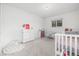 Cozy bedroom with plush carpeting, a changing station, and a bright window at 4663 S Lowell Blvd, Denver, CO 80236