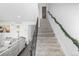 Carpeted staircase with a sleek black railing, connecting different levels of the home at 4663 S Lowell Blvd, Denver, CO 80236