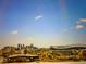 Expansive city skyline view featuring a stadium, with a clear blue sky dotted with clouds, showcasing urban living at 3043 W 19Th Ave, Denver, CO 80204