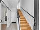 Bright, modern staircase featuring wood steps, black railing, and white walls at 3043 W 19Th Ave, Denver, CO 80204