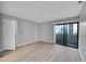 Light filled bedroom with sliding glass doors to a private balcony and modern wood-look floors at 11101 E Alameda Ave # 202, Aurora, CO 80012