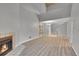 A well-lit living room with a fireplace, high ceiling, wood floors, and adjacent staircase at 11101 E Alameda Ave # 202, Aurora, CO 80012
