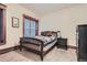 Cozy bedroom with wood-framed windows, neutral walls, and patterned quilt at 1210 E Colfax Ave # 206, Denver, CO 80218