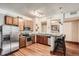 Well-lit kitchen with stainless steel appliances, wood cabinets, and bar seating at 1210 E Colfax Ave # 206, Denver, CO 80218