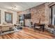 Inviting living room featuring exposed brick wall, fireplace, and hardwood floors at 1210 E Colfax Ave # 206, Denver, CO 80218