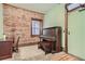 Charming room featuring exposed brick wall, piano, and adjacent desk at 1210 E Colfax Ave # 206, Denver, CO 80218