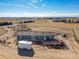 Aerial view of the property highlighting its rural setting and large lot, deck, and outbuildings at 16491 County Road 32, Platteville, CO 80651