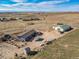 Aerial view of the blue home, the barns, and the surrounding fields at 16491 County Road 32, Platteville, CO 80651