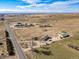 Aerial view of the property, showing the house, barn, fields, and road at 16491 County Road 32, Platteville, CO 80651