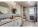 Bright bathroom featuring a double sink vanity, tile flooring, and a shower with decorative tile accents at 16491 County Road 32, Platteville, CO 80651