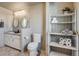 Bathroom features a double-sink vanity, neutral wall paint, tile flooring, and toilet adjacent to shelving at 16491 County Road 32, Platteville, CO 80651