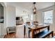 Inviting dining room featuring hardwood floors, a wooden table with bench, and modern chandelier at 16491 County Road 32, Platteville, CO 80651